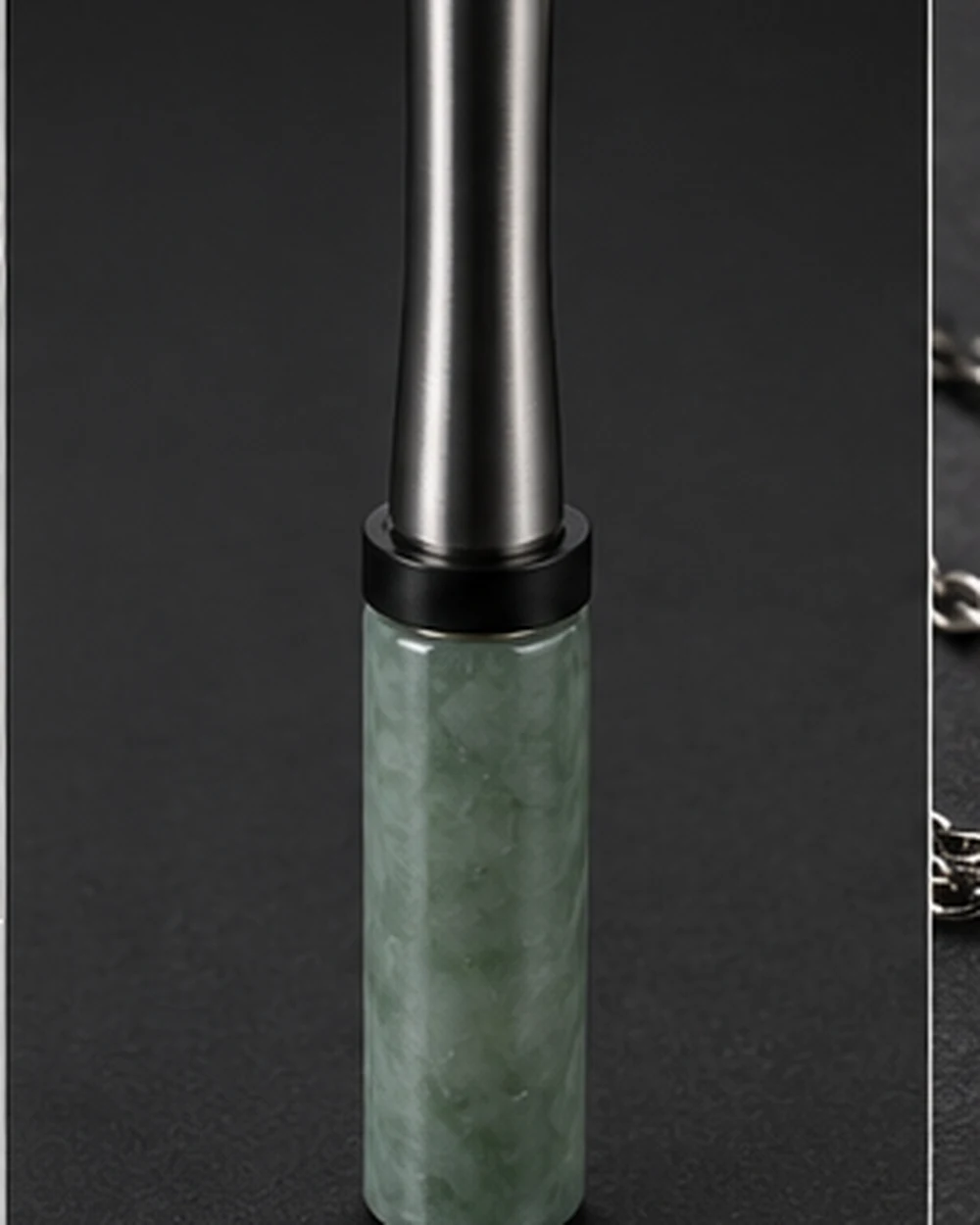 Slim jadeite mouthpiece worn as a pendant on a titanium chain
